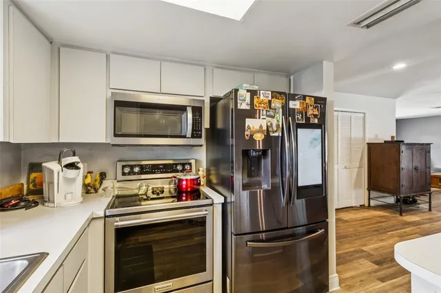 a kitchen with stainless steel appliances a refrigerator stove and microwave