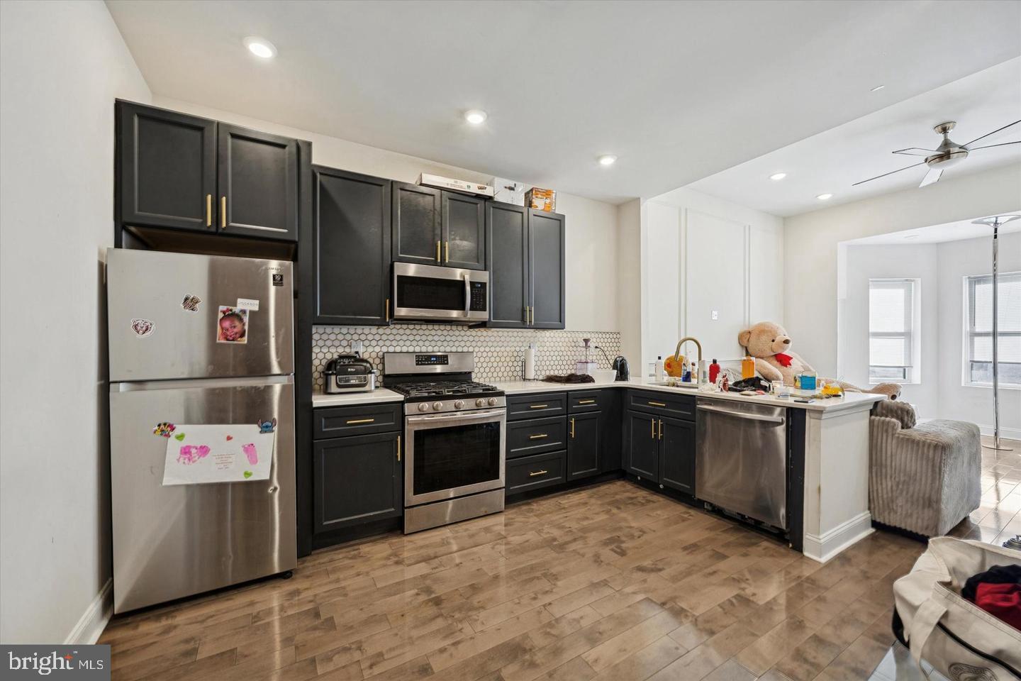 5227 Walnut Street Philadelphia, PA 19139 - Photo 3 of 6 a kitchen with stainless steel appliances kitchen island granite countertop a refrigerator stove microwave and sink