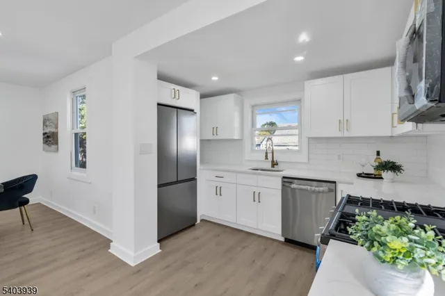 a kitchen with stainless steel appliances granite countertop a refrigerator sink and stove
