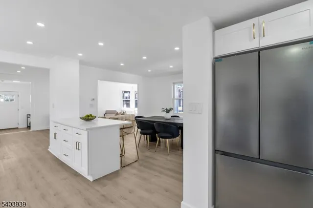 a kitchen with kitchen island white cabinets and stainless steel appliances