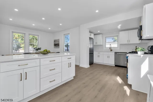 a kitchen with white cabinets and sink