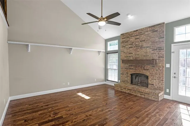 a view of a livingroom with wooden floor staircase and a ceiling fan
