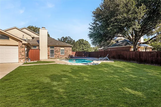 a view of a house with backyard and a tree