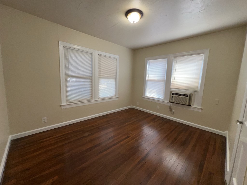 1552 Lombardy Street, Unit 2 Houston, TX 77023 - Photo 12 of 17 an empty room with wooden floor and windows