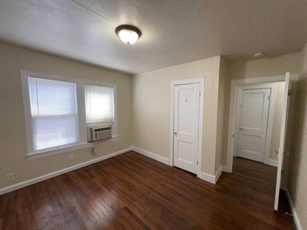 1552 Lombardy Street, Unit 2 Houston, TX 77023 - Photo 13 of 17 an empty room with wooden floor and windows