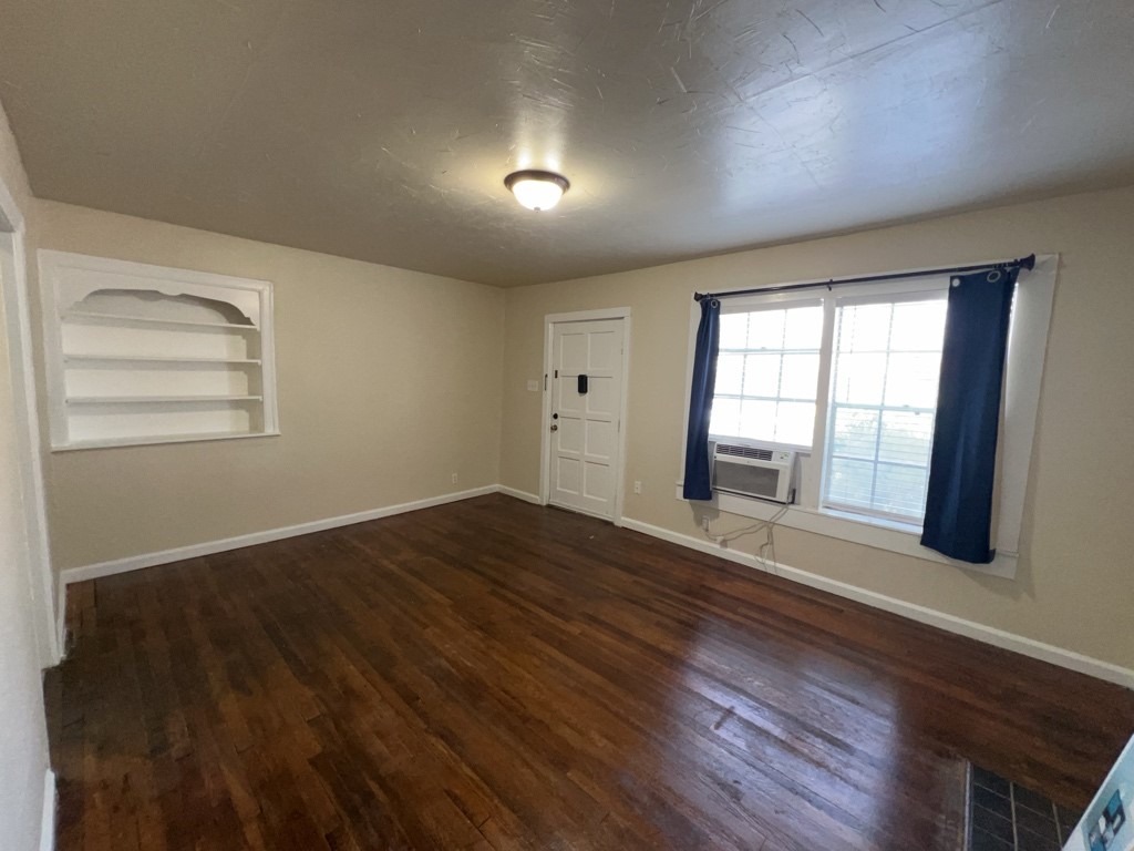 1552 Lombardy Street, Unit 2 Houston, TX 77023 - Photo 6 of 17 a view of an empty room with wooden floor and a window