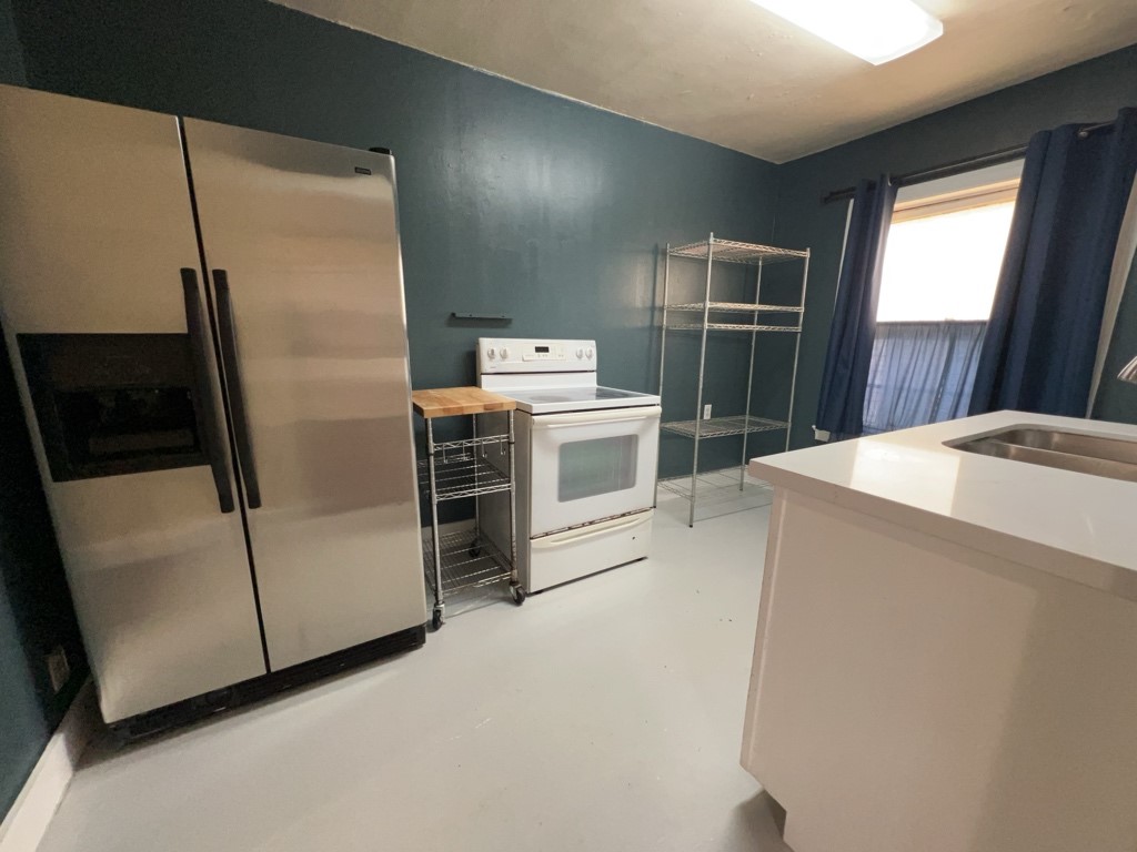 1552 Lombardy Street, Unit 2 Houston, TX 77023 - Photo 9 of 17 a view of a kitchen with a stove fridge and a window