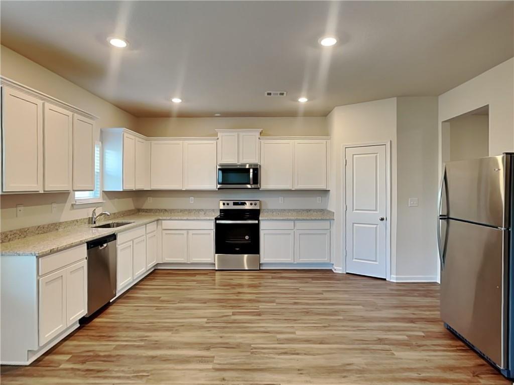 1205 Fendt Drive Locust Grove, GA 30248 - Photo 5 of 19 a large kitchen with a refrigerator and a stove top oven