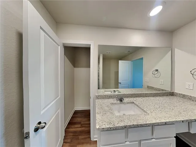 a bathroom with a granite countertop sink and a mirror