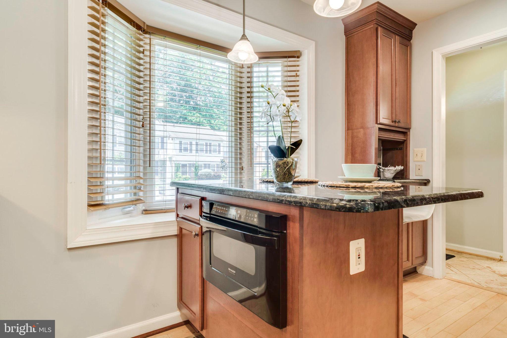 8306 Uxbridge Court Springfield, VA 22151 - Photo 8 of 50 Kitchen Island with eating area and microwave