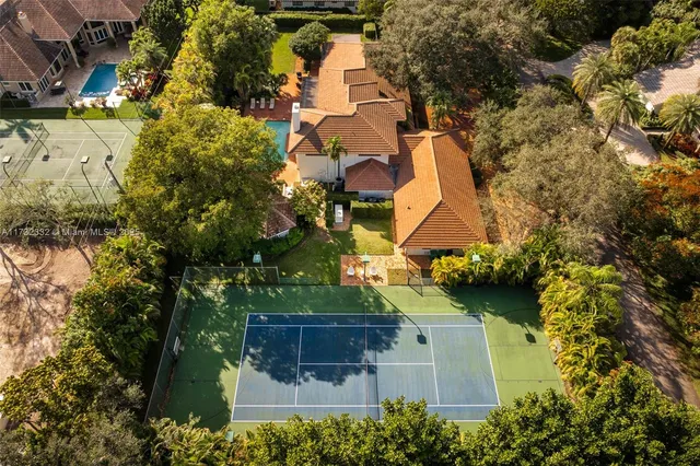 an aerial view of residential houses with outdoor space and trees