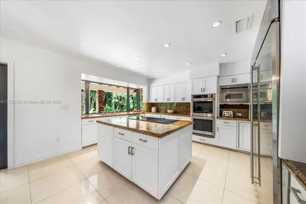 a kitchen with stainless steel appliances granite countertop a refrigerator and a sink