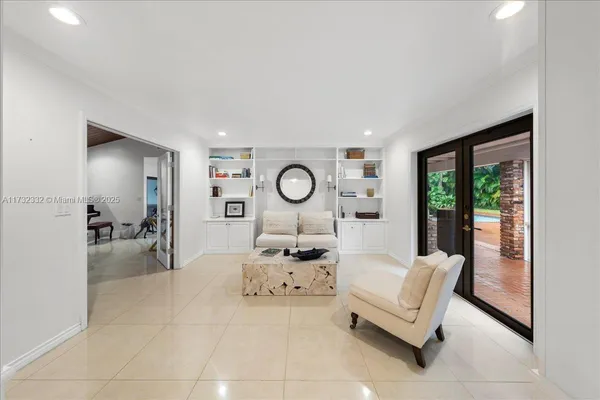 a living room with furniture a large window and gym equipment