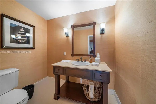 a bathroom with a sink a toilet and mirror