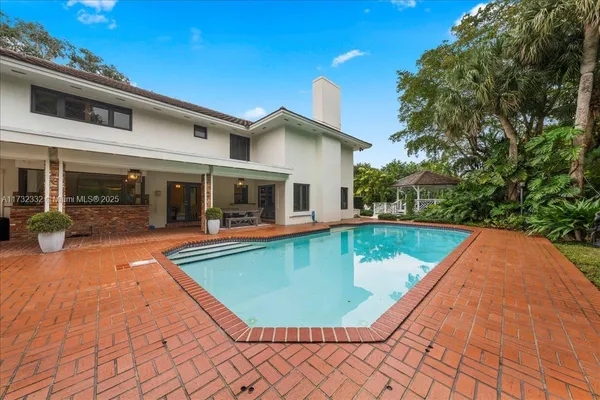 a view of a house with swimming pool and sitting area