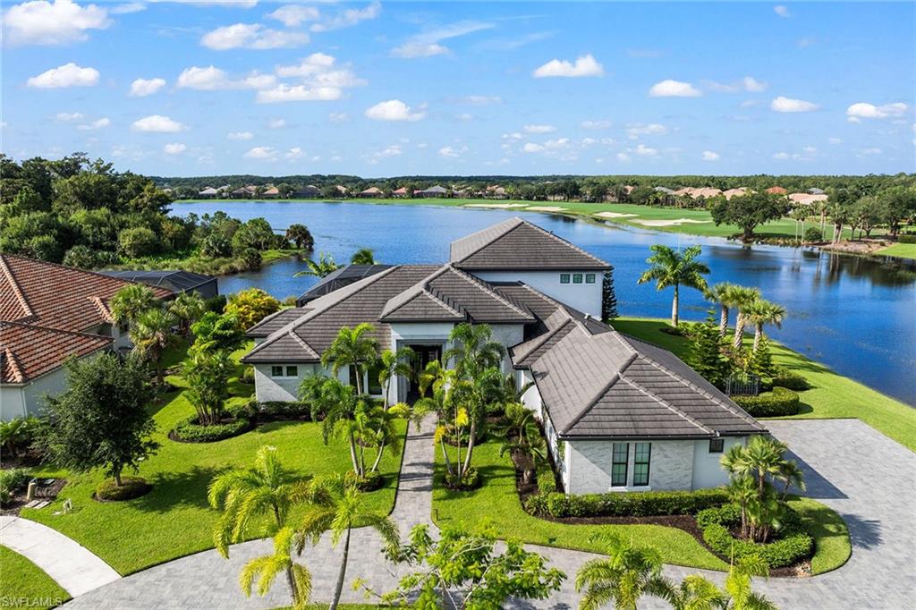 an aerial view of a house with a garden and lake view