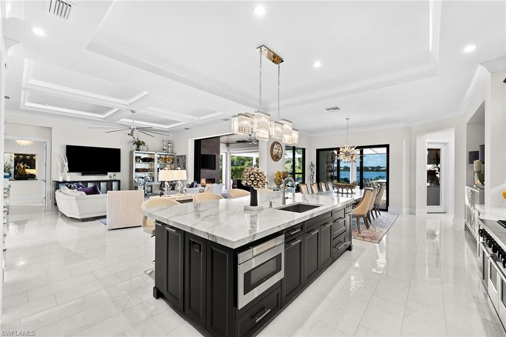 12499 Twin Eagles Boulevard Naples, FL 34120 - Photo 13 of 50 a large kitchen with kitchen island a sink table and chairs