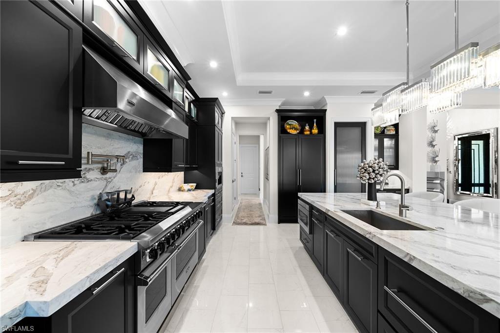 12499 Twin Eagles Boulevard Naples, FL 34120 - Photo 14 of 50 a kitchen with stainless steel appliances a sink stove and cabinets