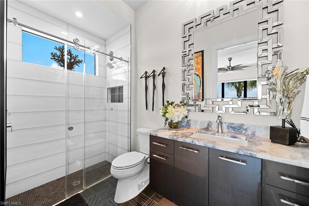 12499 Twin Eagles Boulevard Naples, FL 34120 - Photo 24 of 50 a bathroom with a granite countertop toilet sink and mirror