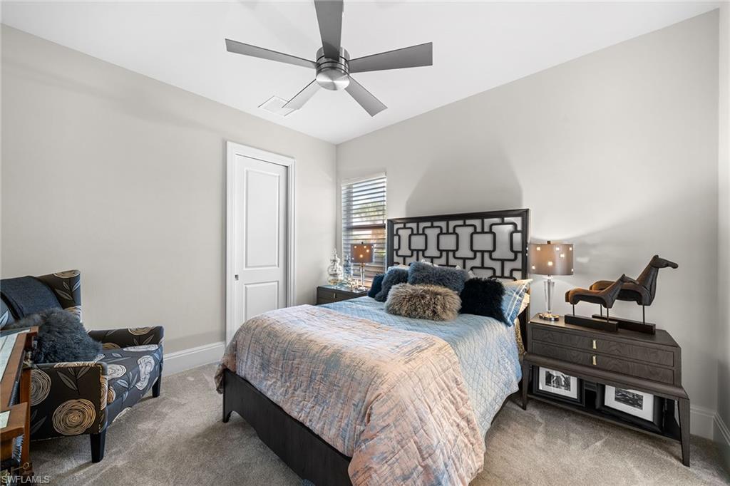 12499 Twin Eagles Boulevard Naples, FL 34120 - Photo 27 of 50 a bedroom with a bed and a chandelier