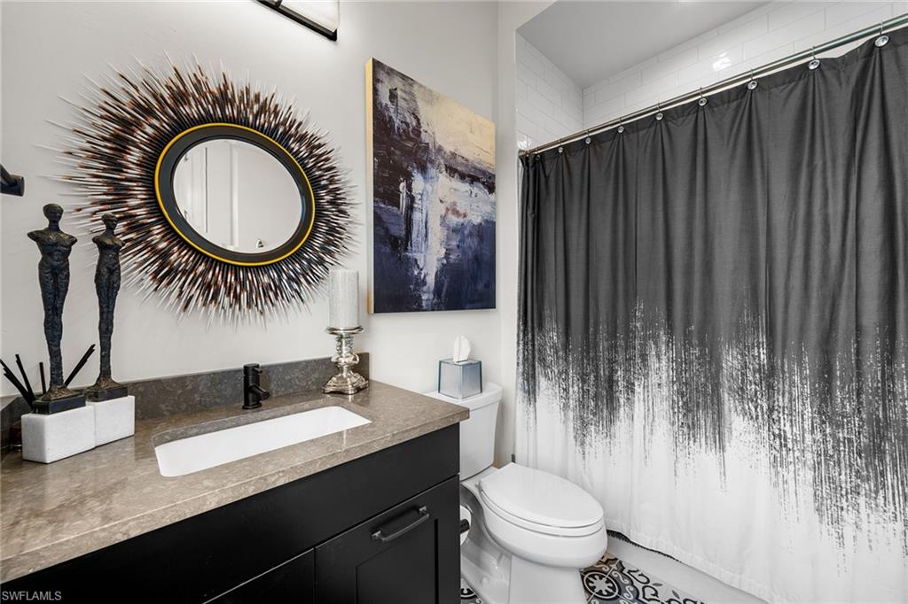 12499 Twin Eagles Boulevard Naples, FL 34120 - Photo 28 of 50 a bathroom with a granite countertop sink and a mirror