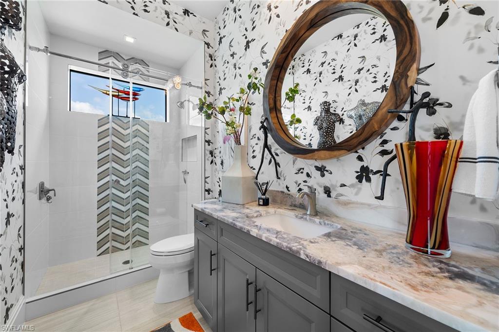 12499 Twin Eagles Boulevard Naples, FL 34120 - Photo 31 of 50 a bathroom with a toilet sink and mirror