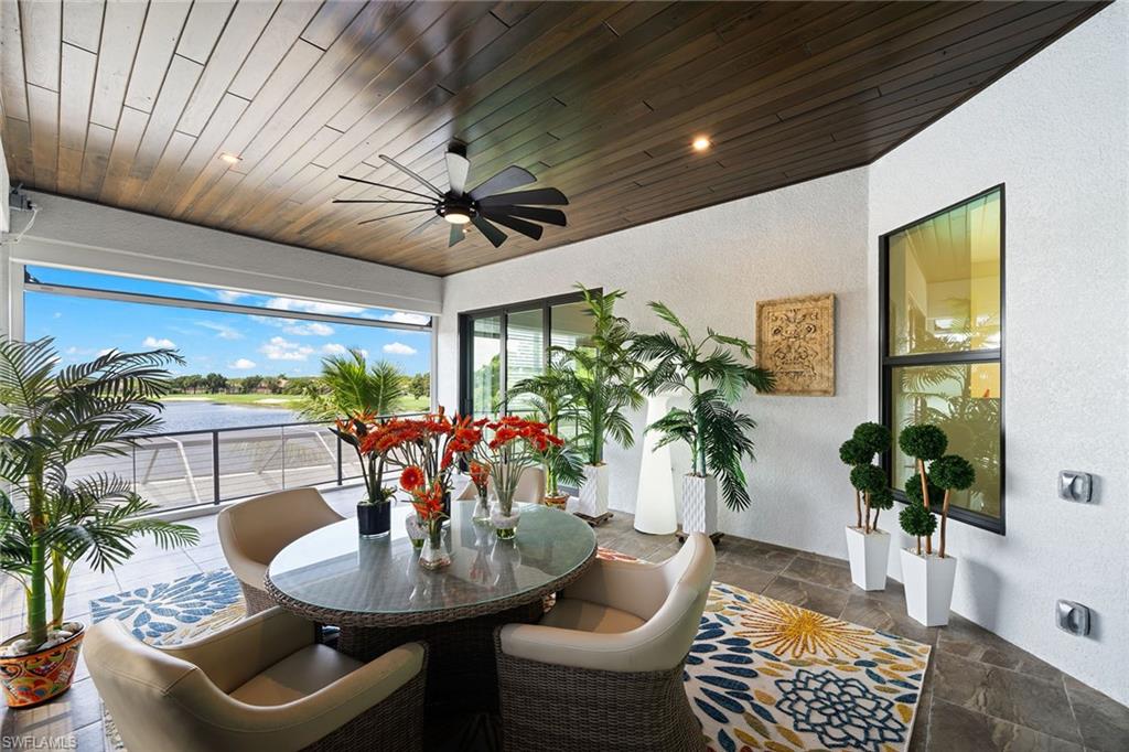 12499 Twin Eagles Boulevard Naples, FL 34120 - Photo 32 of 50 a dining room with furniture a potted plant and a chandelier