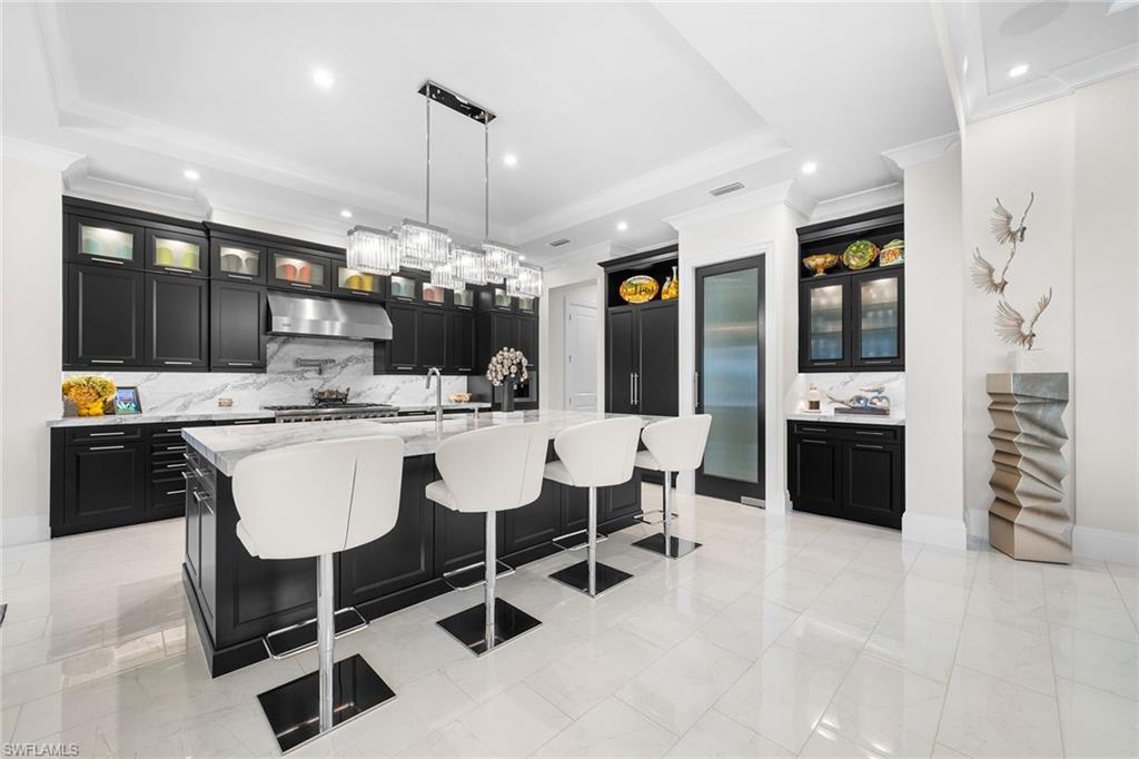 12499 Twin Eagles Boulevard Naples, FL 34120 - Photo 5 of 50 a kitchen with a chandelier dining table and chairs