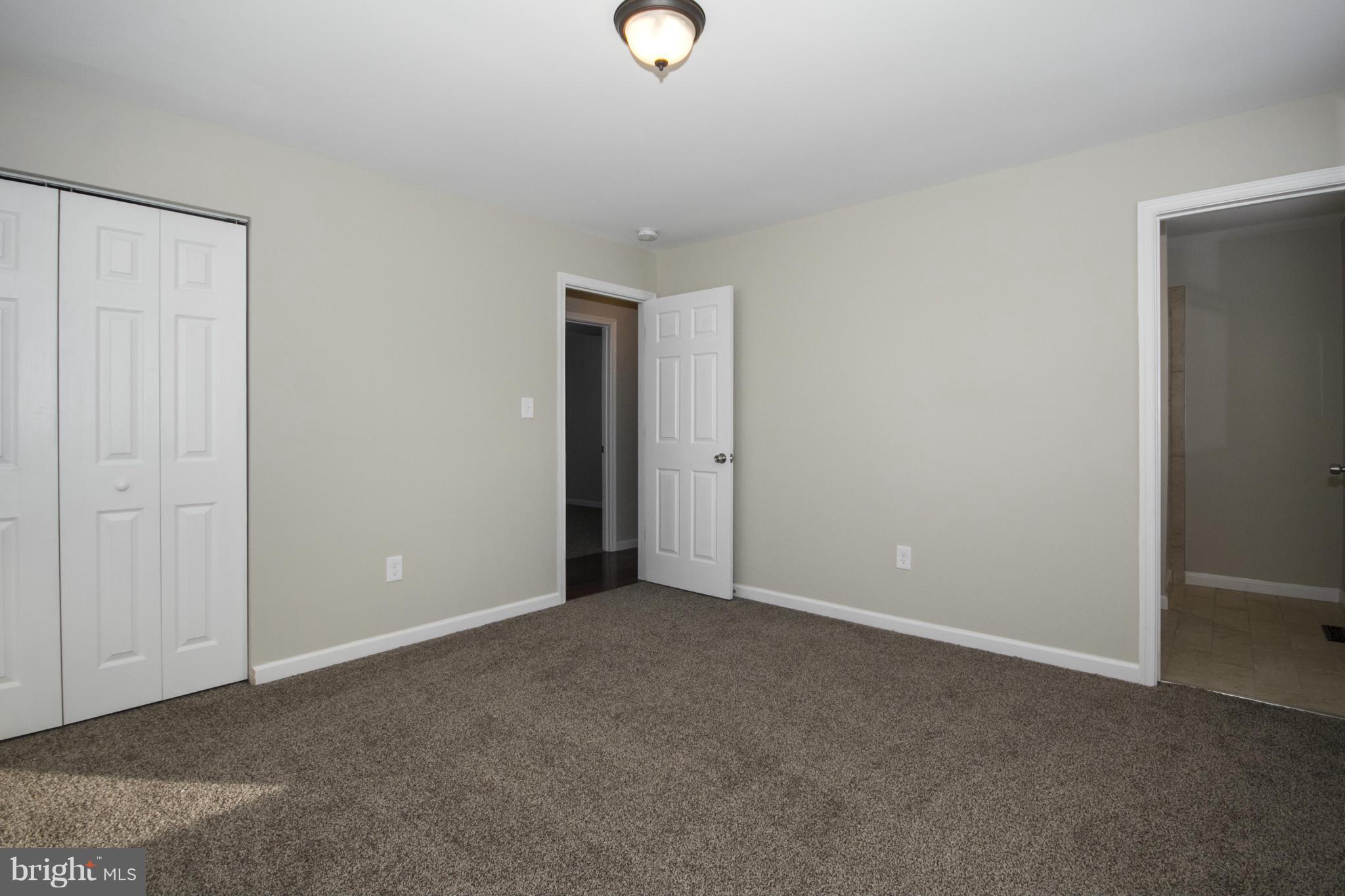 6701 Longhill Road Baltimore, MD 21207 - Photo 14 of 27 a view of an empty room with wooden floor and windows
