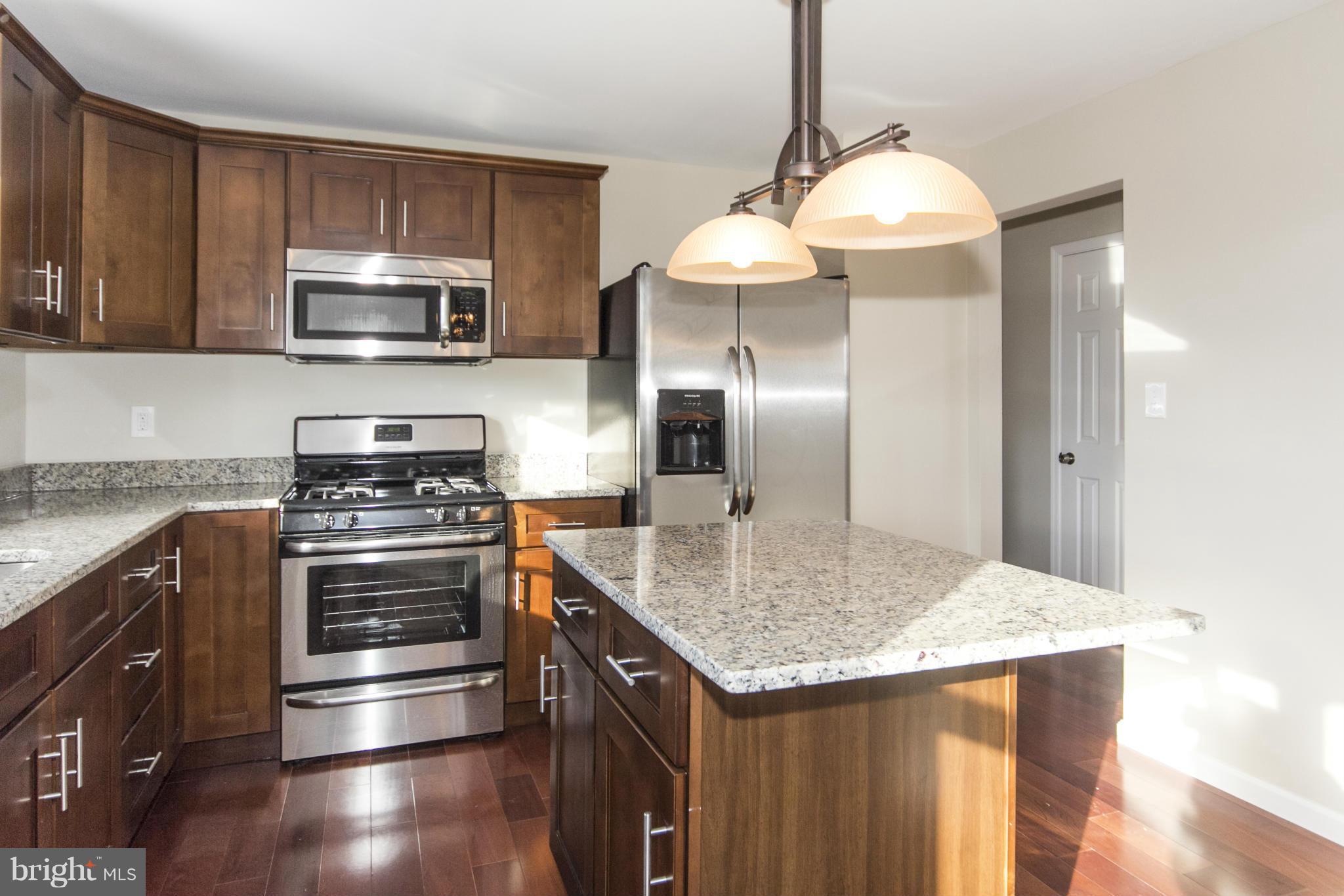 6701 Longhill Road Baltimore, MD 21207 - Photo 4 of 27 a kitchen with stainless steel appliances granite countertop a sink stove and refrigerator