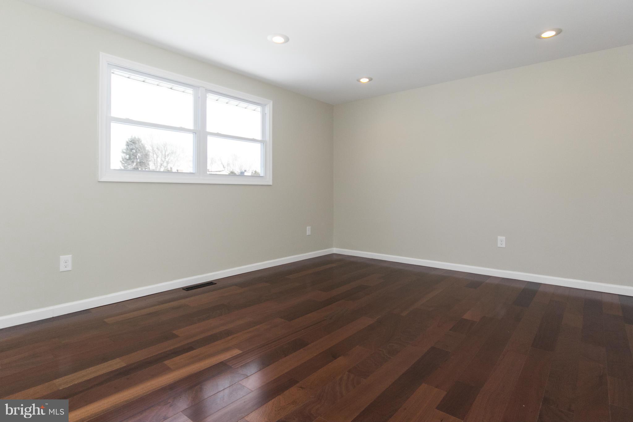 6701 Longhill Road Baltimore, MD 21207 - Photo 6 of 27 a view of an empty room with wooden floor and a window