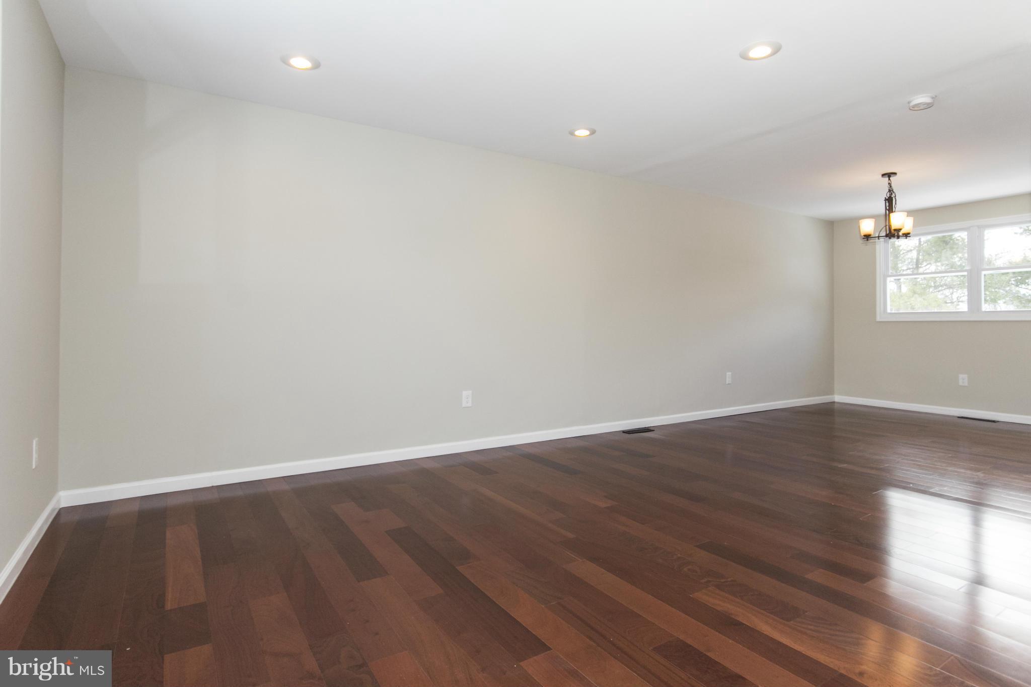 6701 Longhill Road Baltimore, MD 21207 - Photo 7 of 27 an empty room with wooden floor and windows