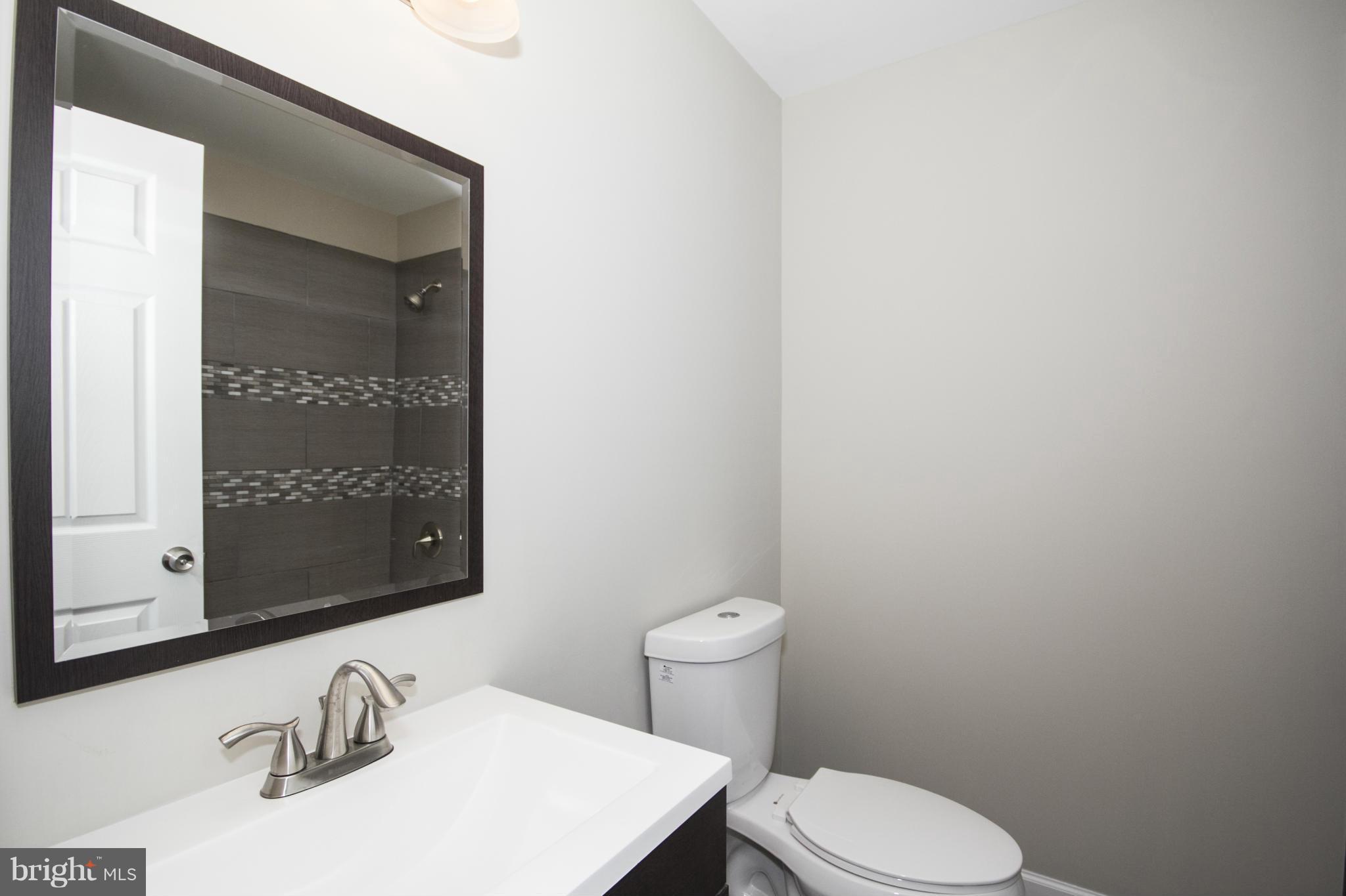 6701 Longhill Road Baltimore, MD 21207 - Photo 9 of 27 a bathroom with a toilet a sink and mirror