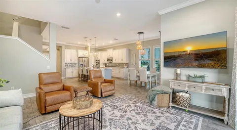 a large white dining hall with stainless steel appliances granite countertop a stove and a refrigerator