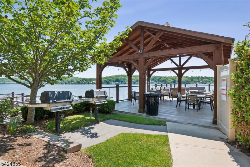 401 Mariners Pointe Hopatcong, NJ 07843 - Photo 2 of 42 a view of a patio with chairs and a table and chairs under an umbrella