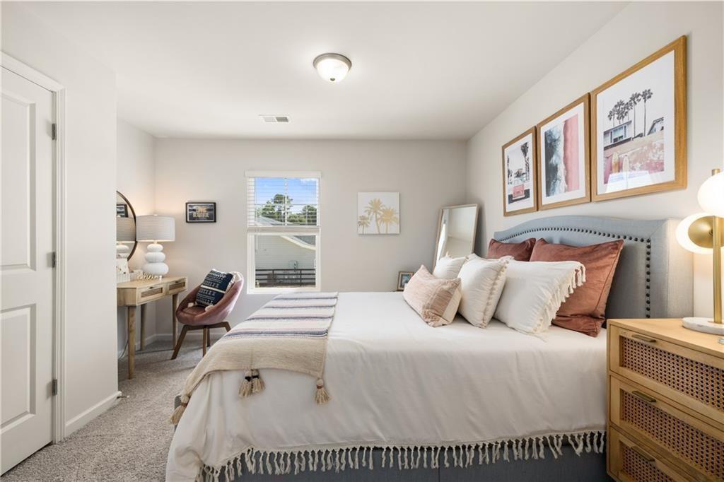 41 Huntley Trace, Unit 5 Hoschton, GA 30548 - Photo 20 of 26 a bedroom with a large bed and a large mirror