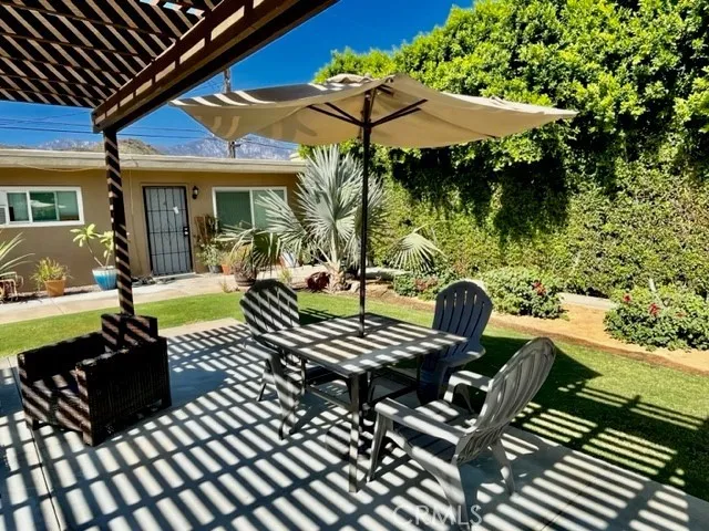 a view of a patio with a table chairs and a potted plant