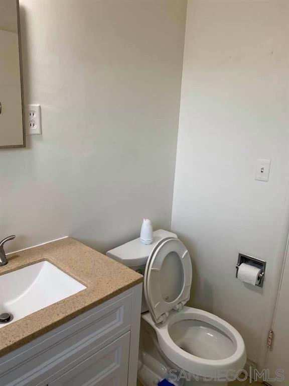 317 Prospect Street La Jolla, CA 92037 - Photo 15 of 24 a bathroom with a granite countertop toilet and a sink