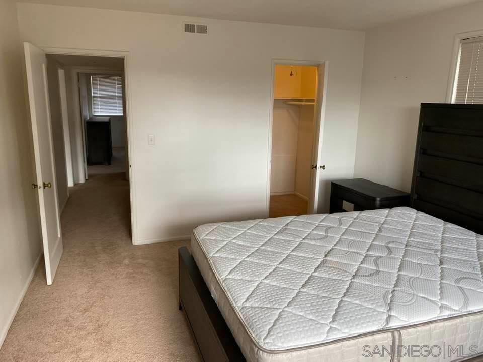 317 Prospect Street La Jolla, CA 92037 - Photo 18 of 24 a bedroom with a bed and a lamp