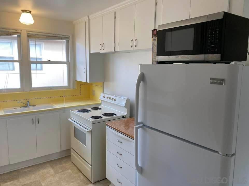 317 Prospect Street La Jolla, CA 92037 - Photo 7 of 24 a kitchen with stainless steel appliances a stove a microwave and a refrigerator
