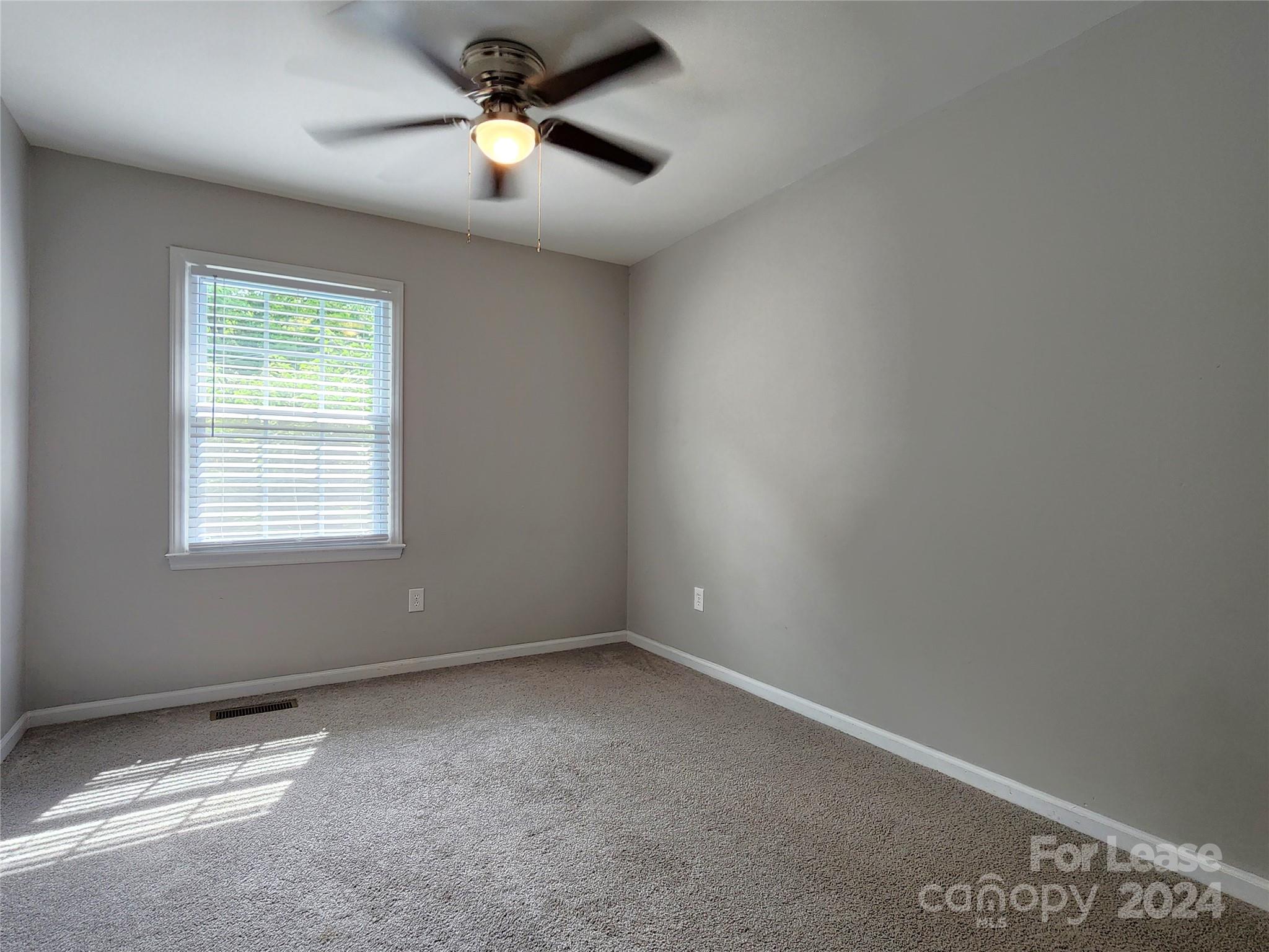 407 Spring Street Northwest, Unit 407 Concord, NC 28025 - Photo 16 of 19 a view of room with a ceiling fan and window