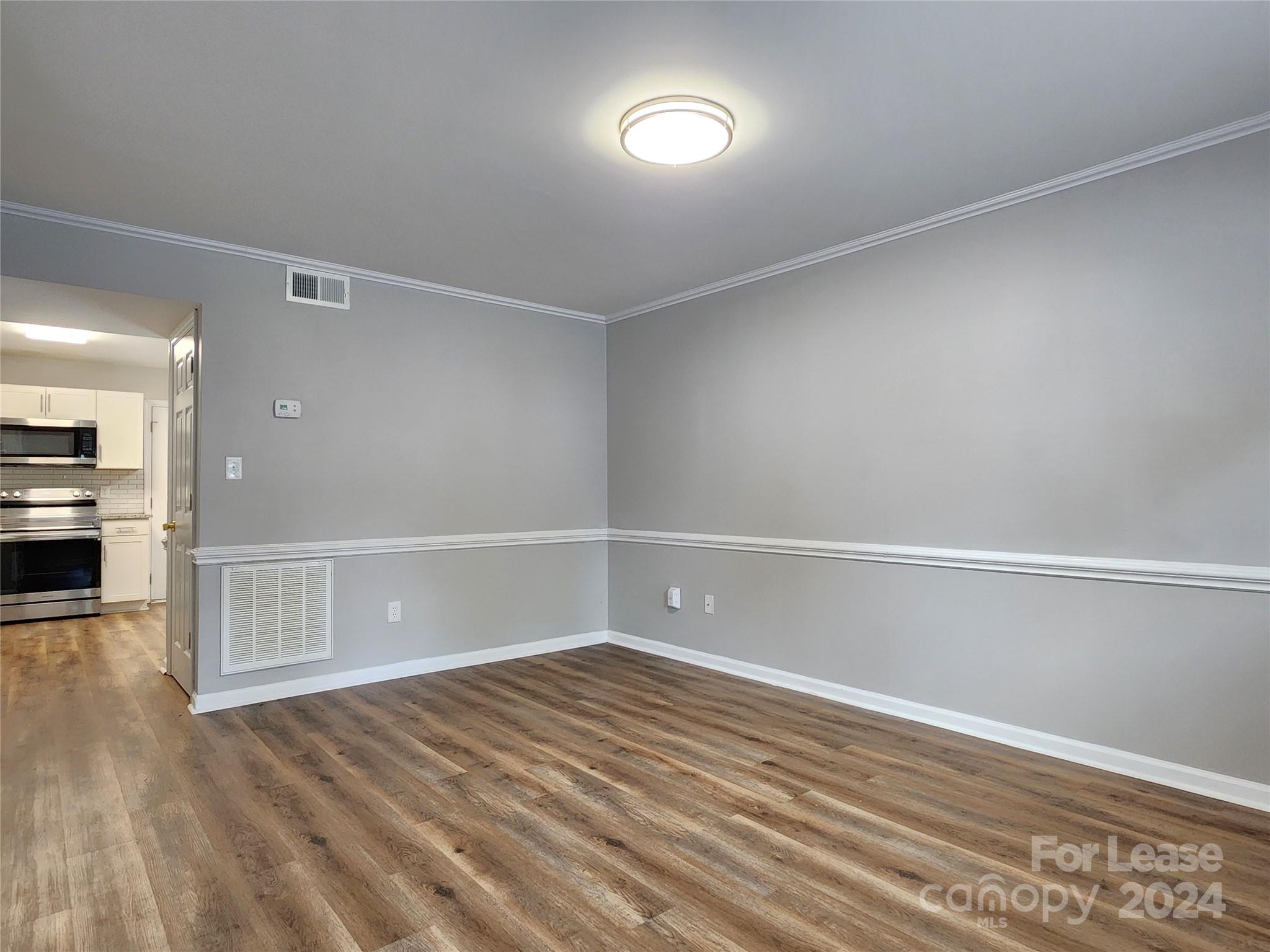 407 Spring Street Northwest, Unit 407 Concord, NC 28025 - Photo 4 of 19 a view of an empty room with wooden floor
