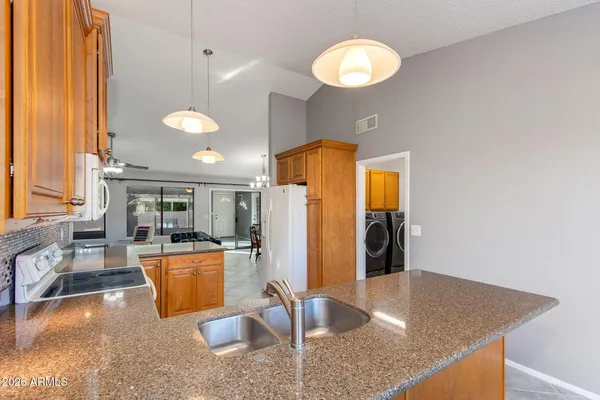 a kitchen with stainless steel appliances granite countertop a sink and a refrigerator