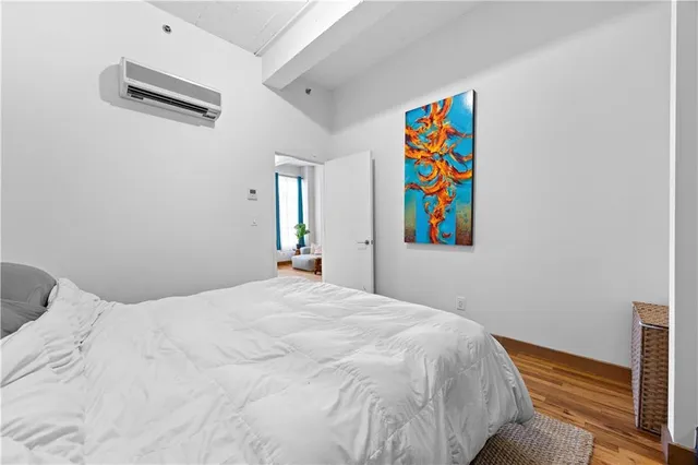 a bedroom with a bed and a painting on the wall