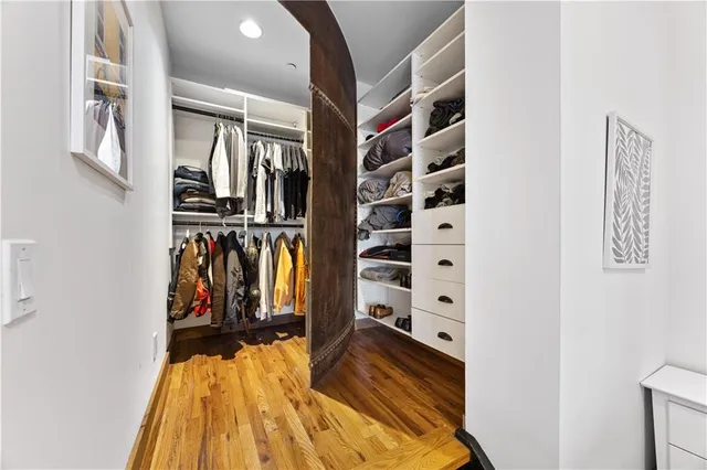 a view of walk in closet with clothes and shoes