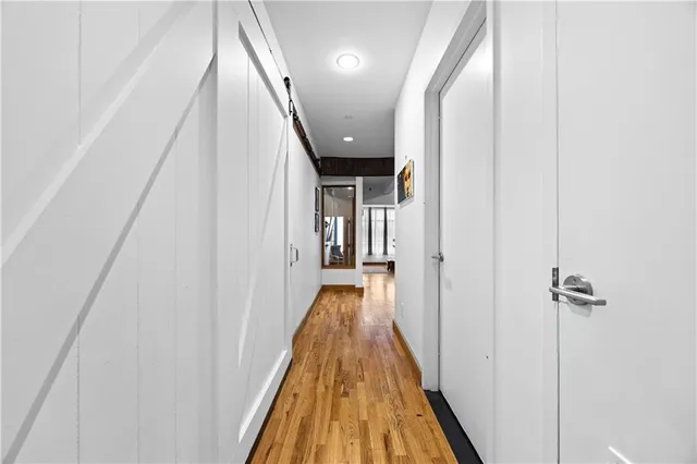 a view of a hallway with wooden floor and staircase