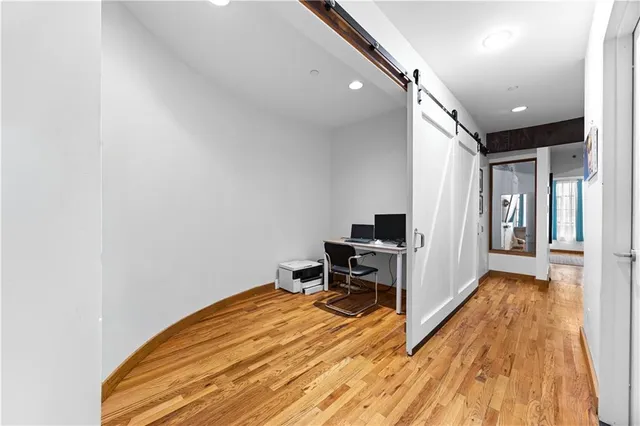 a view of a hallway with wooden floor and furniture