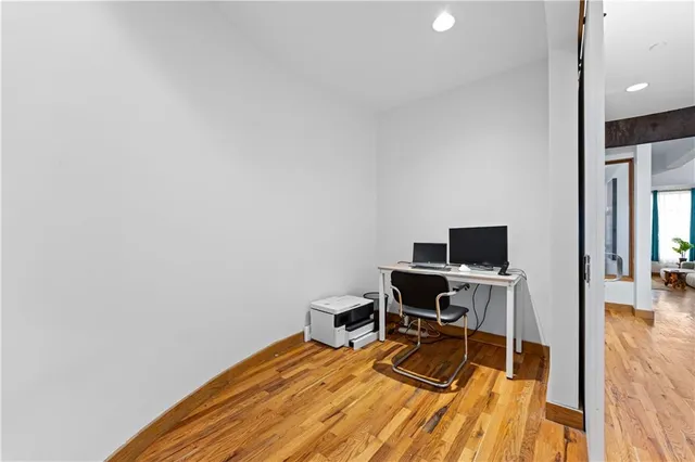 a view of a workspace with wooden floor