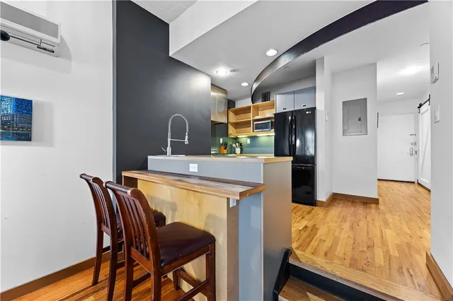 a kitchen with kitchen island wooden cabinets and refrigerator