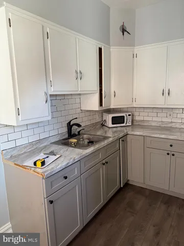 a kitchen with sink cabinets and white appliances